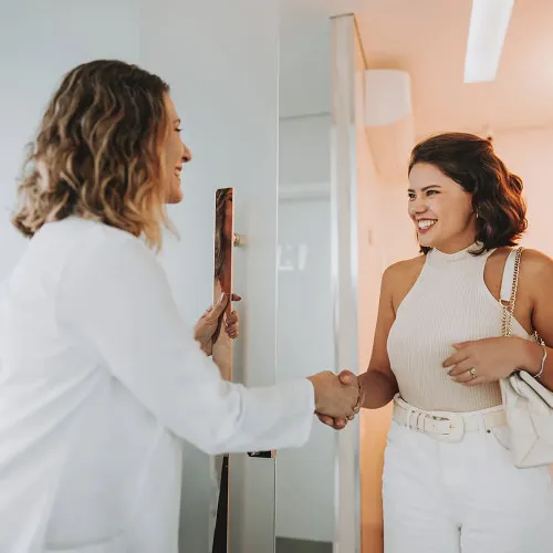 Medical professional welcoming a female patient